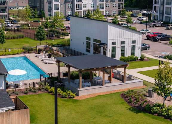 A white building with a pool in the backyard.