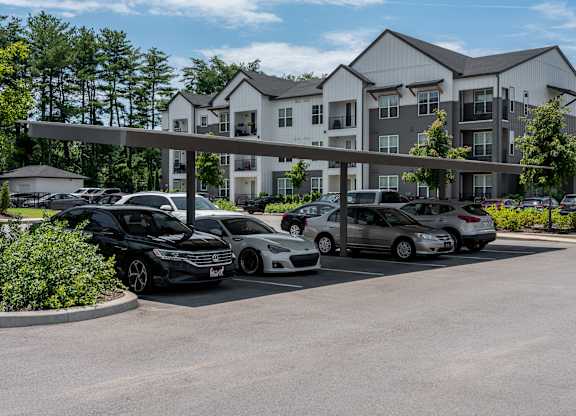 A parking lot with cars and a building in the background.