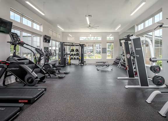 A spacious gym with treadmills, elliptical machines, and weightlifting equipment.