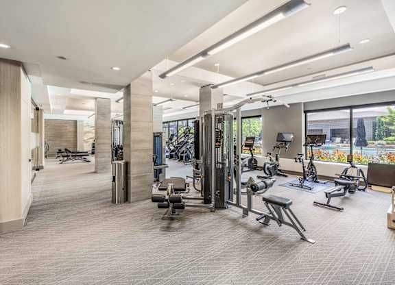 A spacious gym with a variety of equipment and a view of the outdoors.