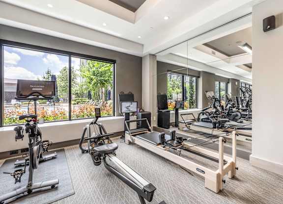 A spacious gym with treadmills, exercise bikes, and a television.