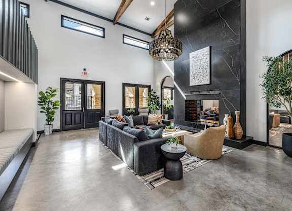 A modern living room with a grey sofa and a black coffee table.
