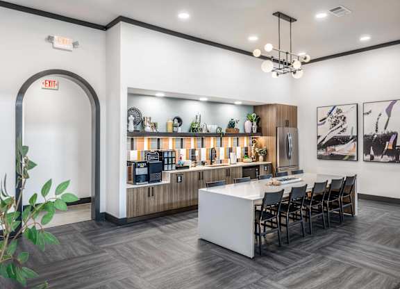 A modern kitchen with a bar area and a dining table set up.