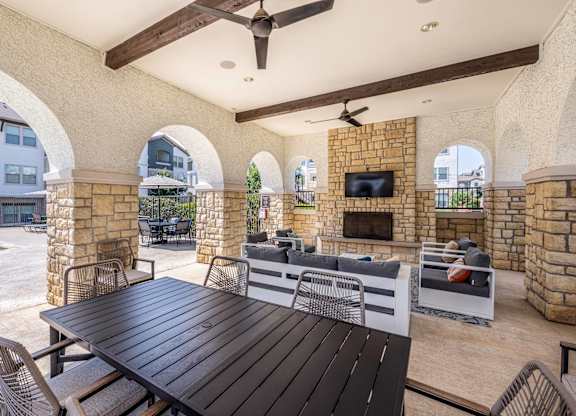 A patio with a table and chairs and a television.