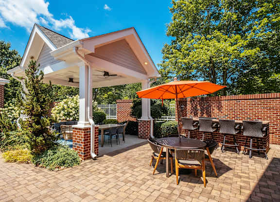 A patio with a table and chairs under a white roof.