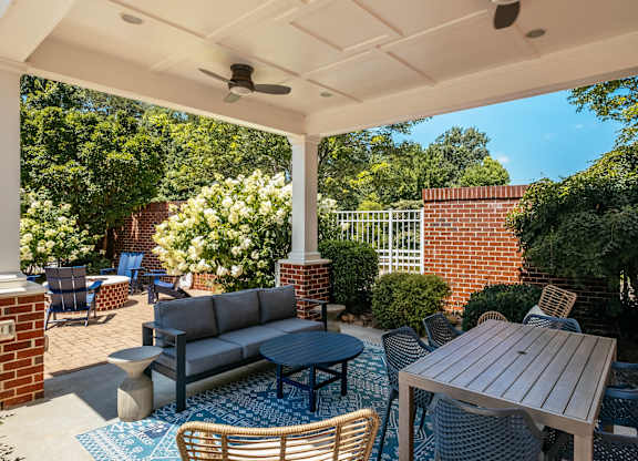 A patio with a table and chairs under a roof.