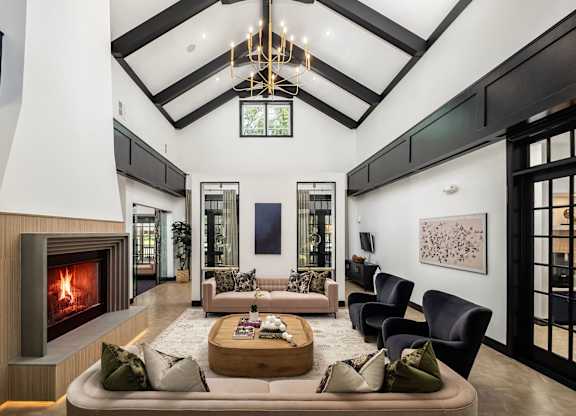 A modern living room with a fireplace and a large painting on the wall.