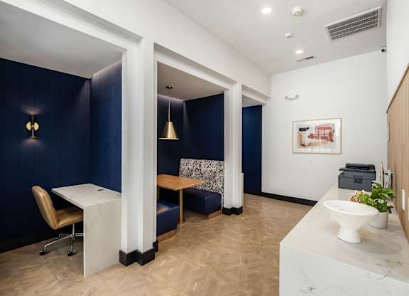 A bathroom with a sink, toilet, and a chair.