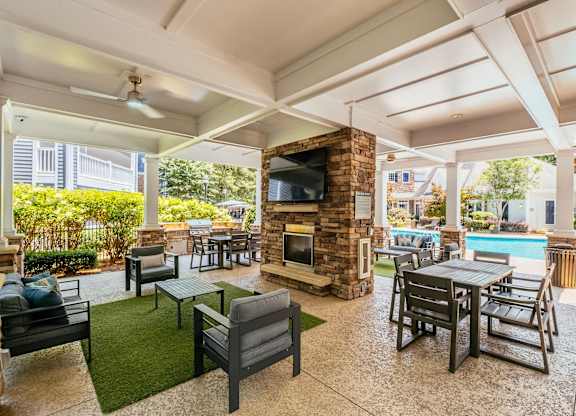 A patio with a fireplace and chairs.