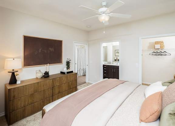 A bedroom with a large bed and a wooden dresser.
