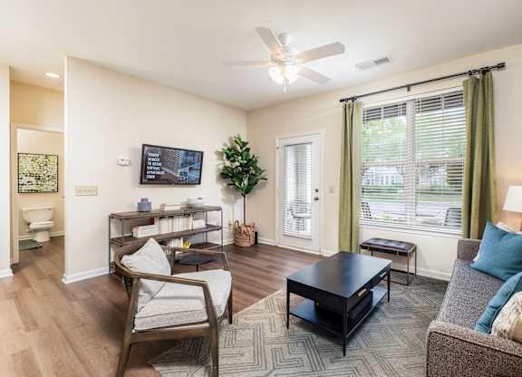 A living room with a couch, chair, and television.