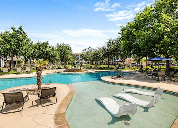 A pool with a palm tree in the middle of it.