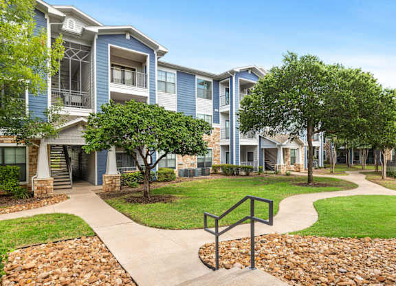 A residential area with apartment buildings and a walkway.