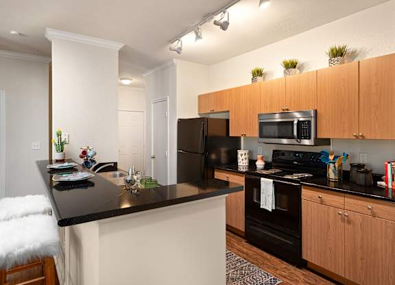 A kitchen with a black countertop and white walls.