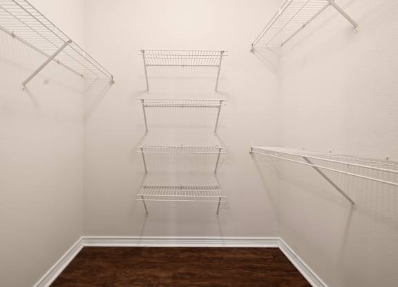 Empty room with white walls and brown floor.