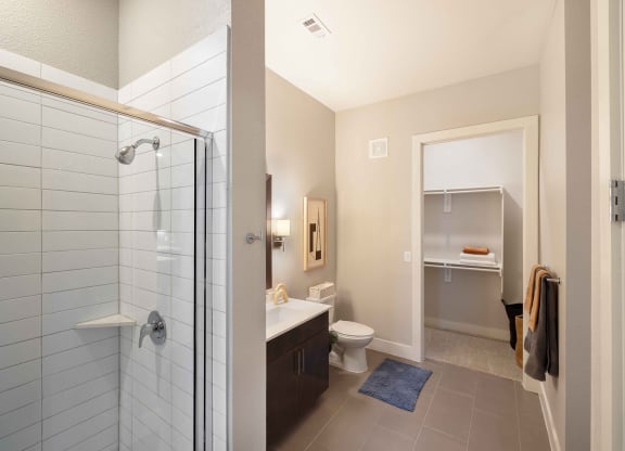 a bathroom with a shower and a toilet and a sink