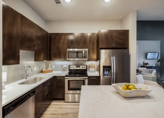 a kitchen with stainless steel appliances and marble counter tops