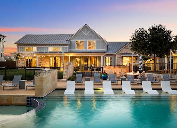 A large house with a pool in front of it.