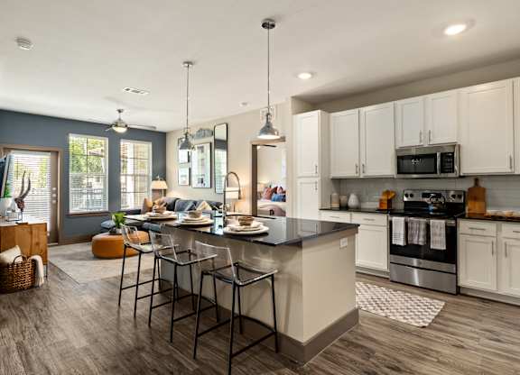 A modern kitchen with a large island and stainless steel appliances.