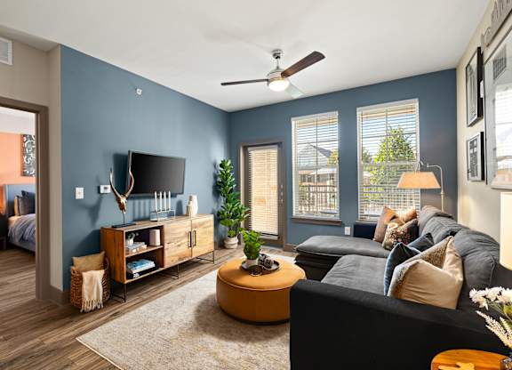 A living room with a black couch and a television.