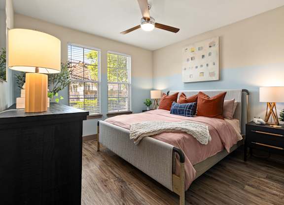 A bedroom with a bed, nightstand, and a ceiling fan.