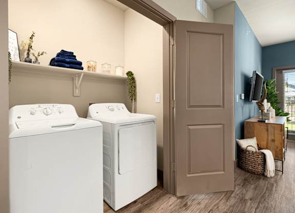 Two white front loading washing machines in a laundry room.