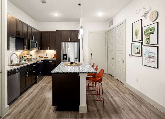 A kitchen with a table and chairs in the middle of the room.