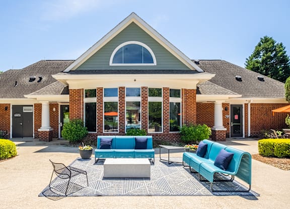 A house with a blue couch and a black chair in front of it.
