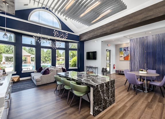 A modern kitchen with a marble island and a dining table set for four.