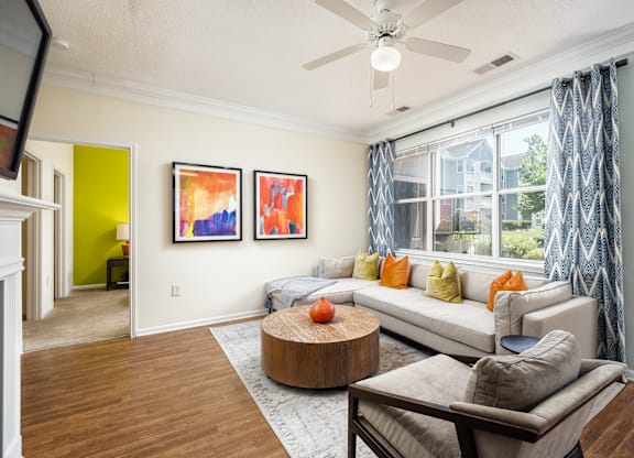 A living room with a couch, a coffee table, and a ceiling fan.