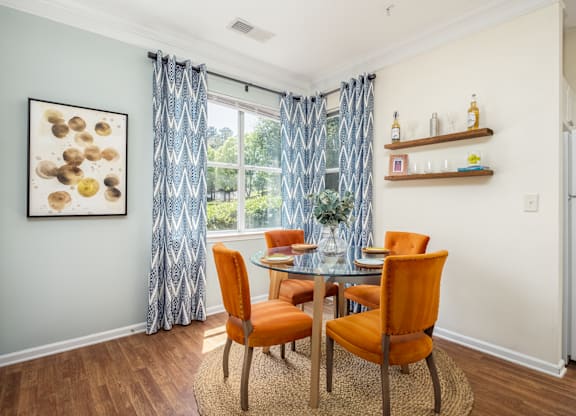 A dining room with a table and chairs.