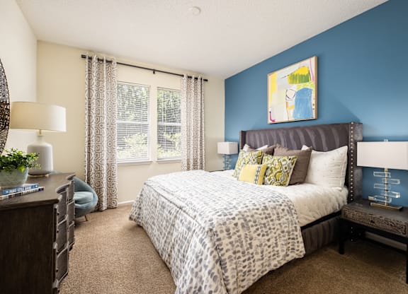 A bedroom with a large bed and a blue wall.