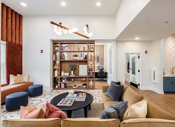 a living room with couches and a coffee table in front of a book shelf