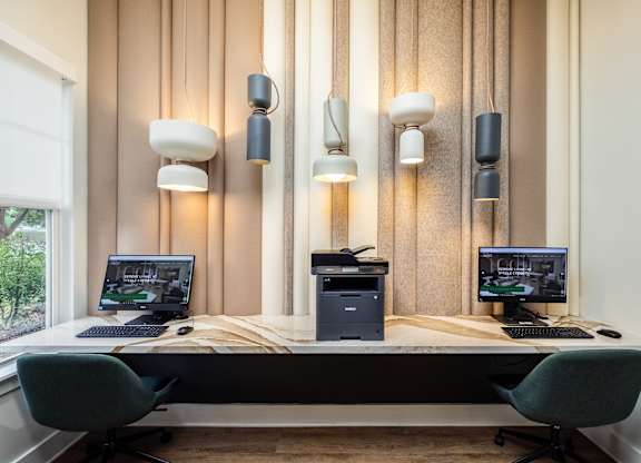 a desk with two computers and three monitors on it