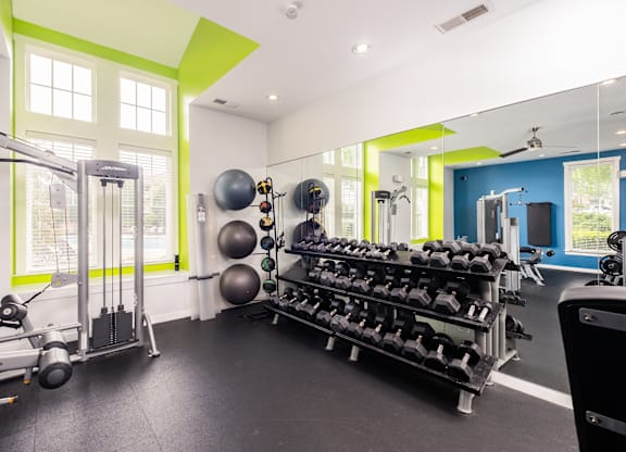 A gym with a variety of equipment including weights and exercise balls.