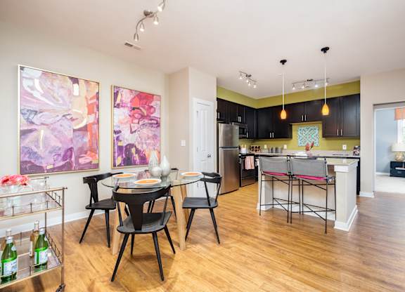 A kitchen with a dining table and chairs in the middle of the room.