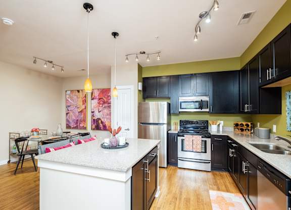 A kitchen with black cabinets and a white island.