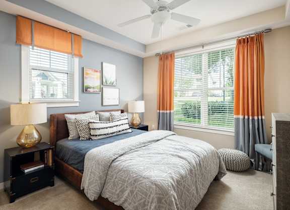 A bedroom with a large bed and a ceiling fan.