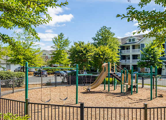 A playground with a slide, swings, and a sandbox.