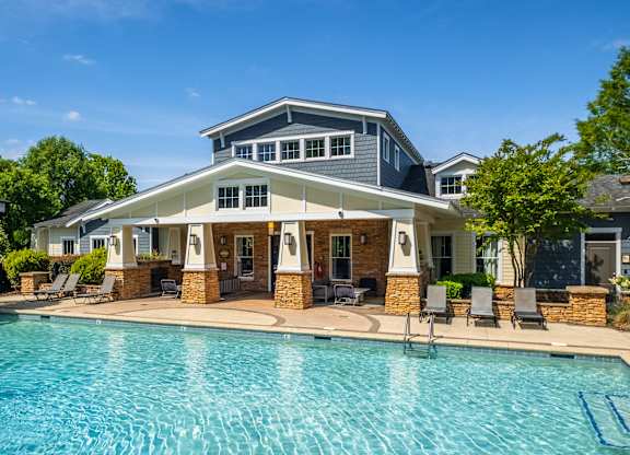 A large house with a pool in front.