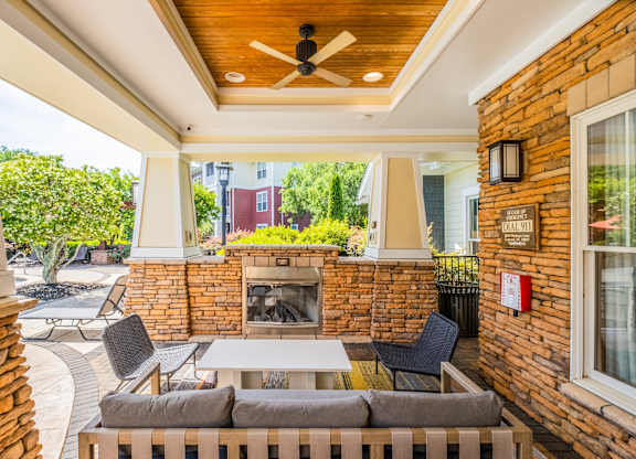 A patio with a brick fireplace and a white table.
