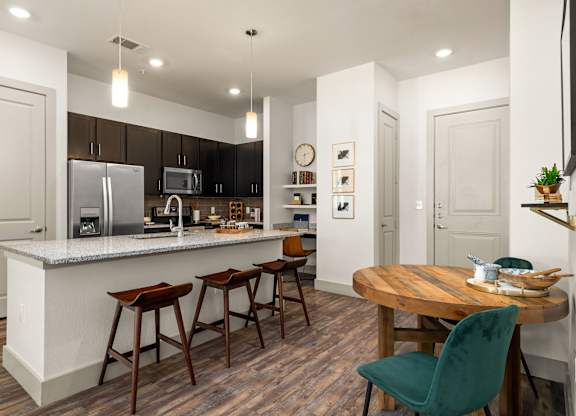 A kitchen with a white countertop and wooden floors.