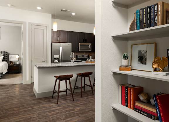 A kitchen with a white counter and brown bar stools.