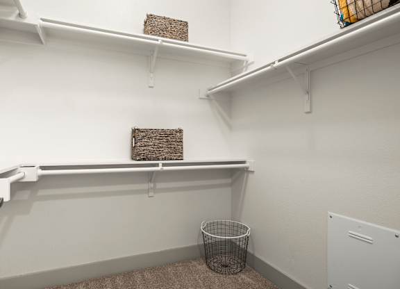 A small room with a wire basket on the floor.
