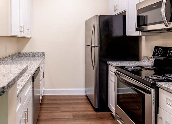 a kitchen with stainless steel appliances and white cabinets