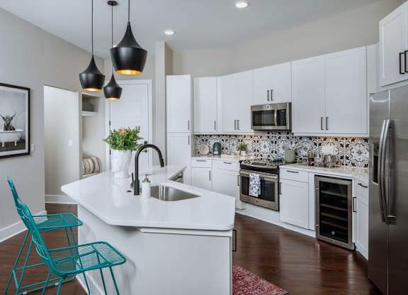 a large kitchen with white cabinets and a sink