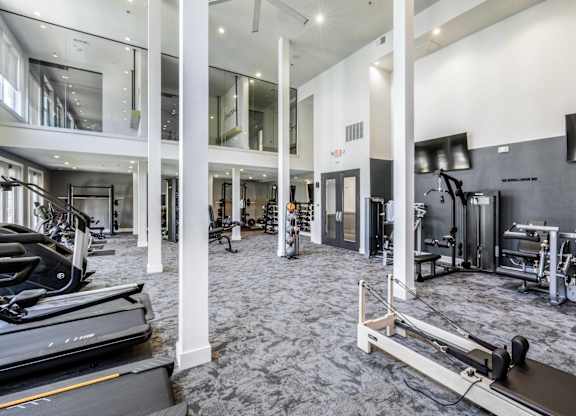 A gym with treadmills, weights, and exercise equipment.