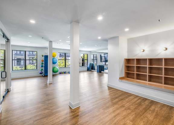 A spacious room with wooden floors and white walls.