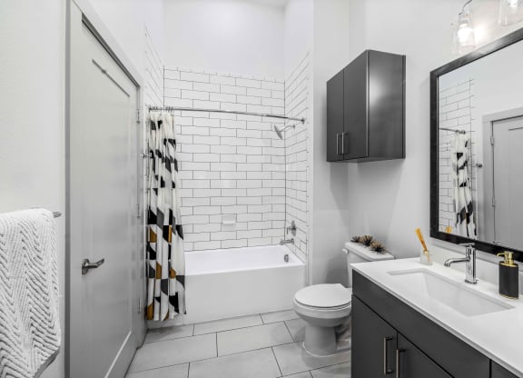 a white bathroom with a shower and a toilet and a sink