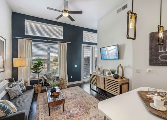 a living room with blue walls and a ceiling fan